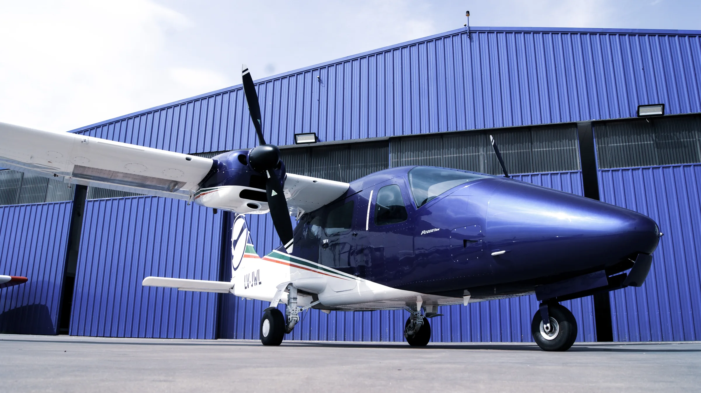 Twin-engine aircraft in front of the maintenance hangar